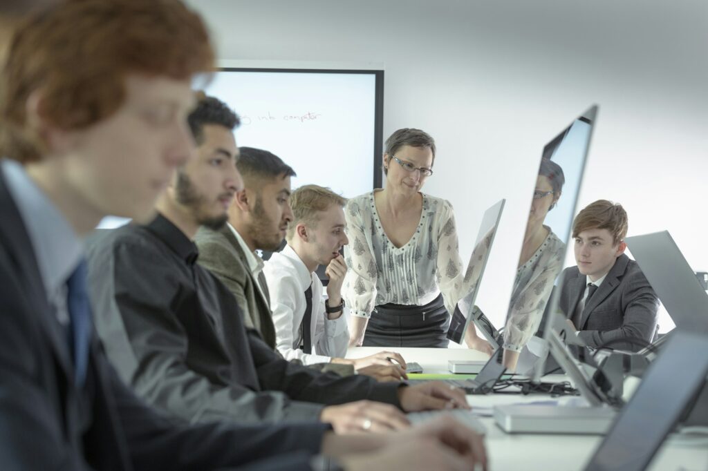 Teacher with engineering apprentices in classroom of railway engineering facility